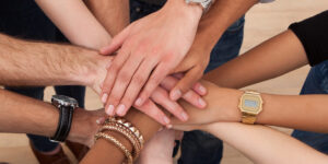 High angle view of multiethnic college students stacking hands in classroom